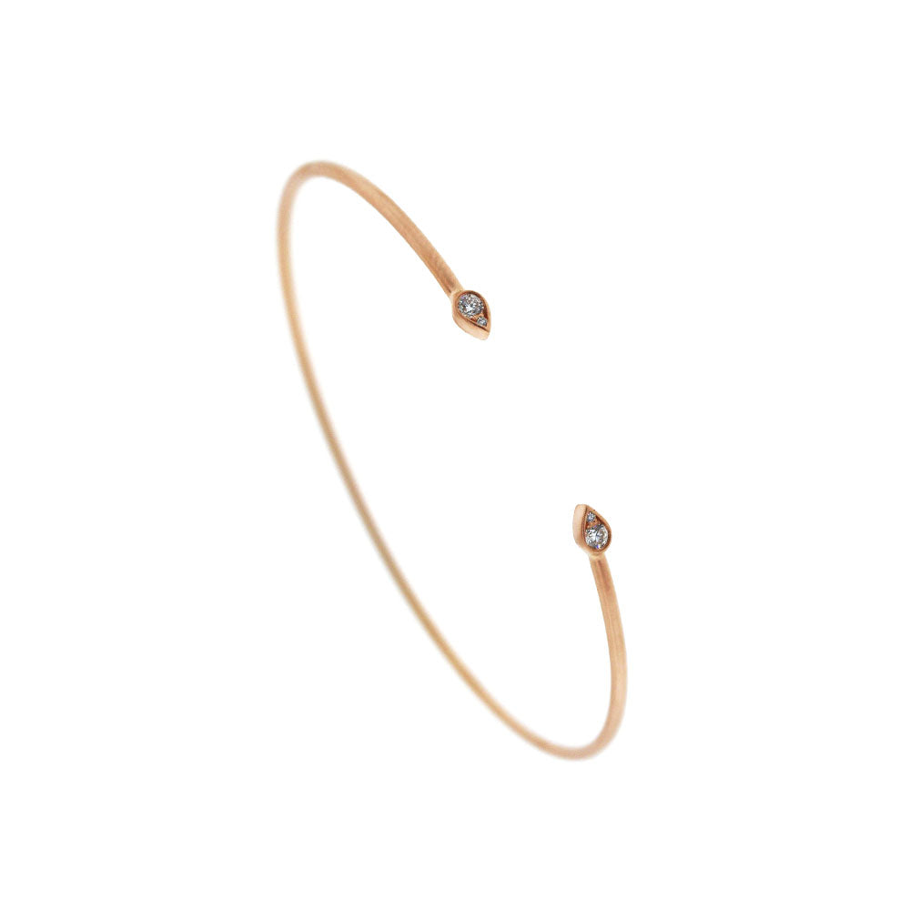 A 14K matte rose gold cuff bracelet featuring round diamonds, elegantly designed as an open flexi bangle