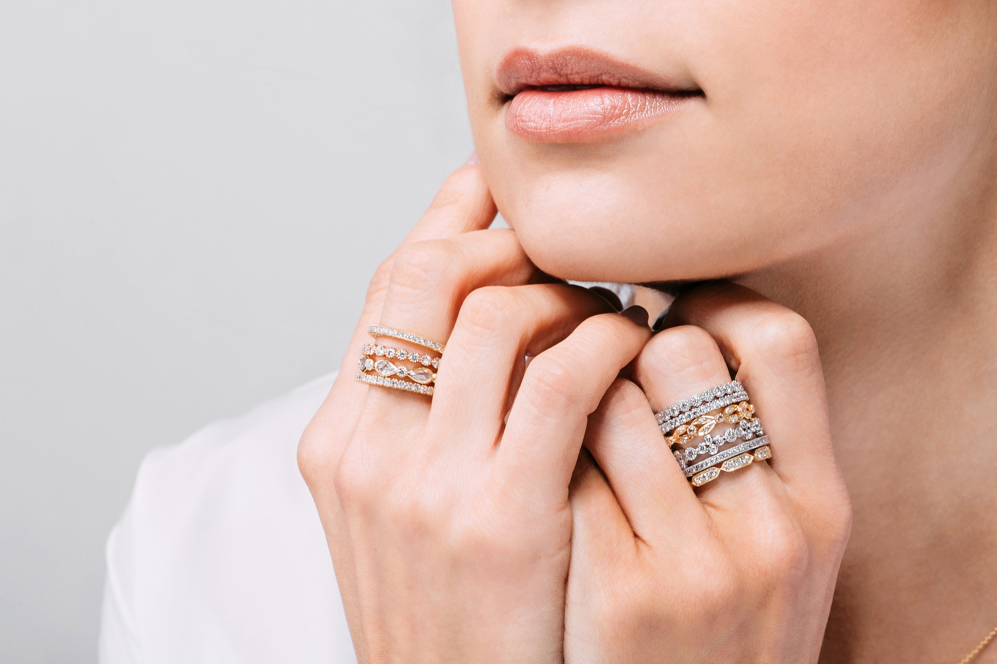 Stylish woman showcasing her stack of rings, highlighting a mesmerizing 18k yellow gold diamond band